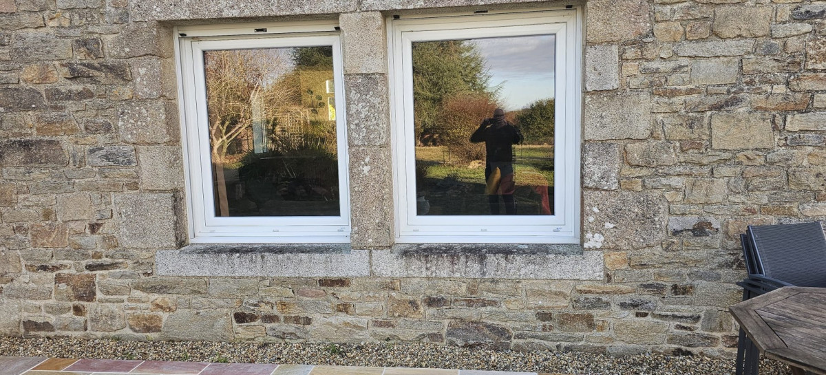 Fenêtres double vitrage blanches dans une maison en pierre